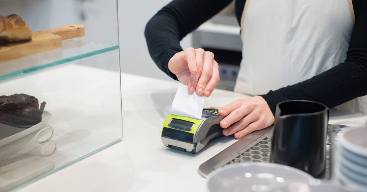Customer receiving a receipt at a point-of-sale counter, illustrating ZIMRA FDMS fiscalisation for Zimbabwean businesses