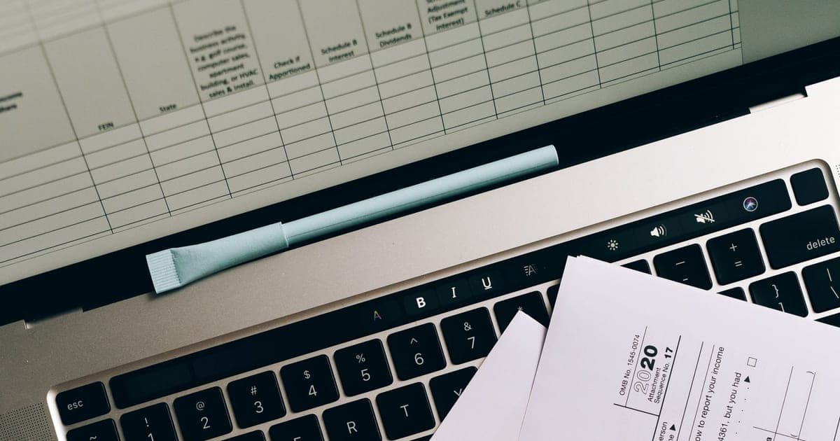 Laptop, paperwork and calculator on a desk representing website and app development pricing in Zimbabwe